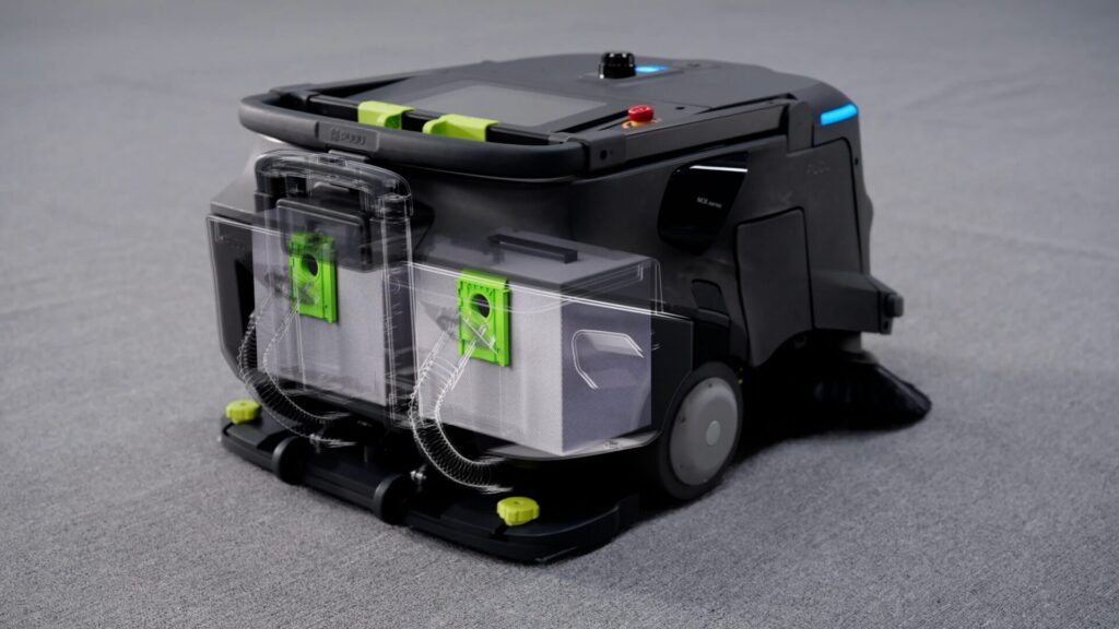 PUDU MT1 Vac mit transparent dargestelltem Dual-Filter und zwei Staubbeuteln auf Teppichboden.