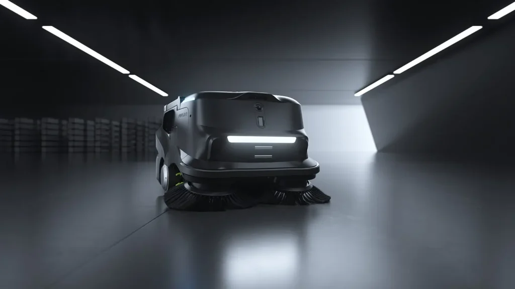 PUDU MT1 autonomer Kehrsaugroboter auf glänzendem Industrieboden in dunkler Halle, Frontansicht mit Lichtleiste.